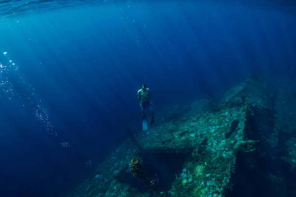 istock Free diver man dive underwater at shipwreck in Bali 1077999716