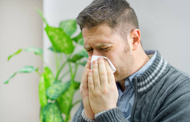 istock Handsome unshaved man blowing nose to napkin. 1078001046