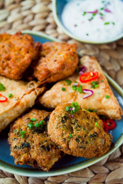 istock Indian Vegetable snacks -  pakora, samosa, onion bhaji with coriander and chili. 1078001054