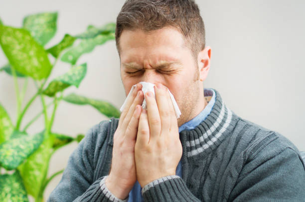 istock Handsome unshaved man blowing nose to napkin. 1078001086