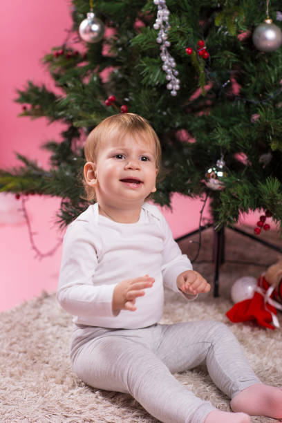 istock baby with wool scarf and hat by the Christmas tree 1078002030