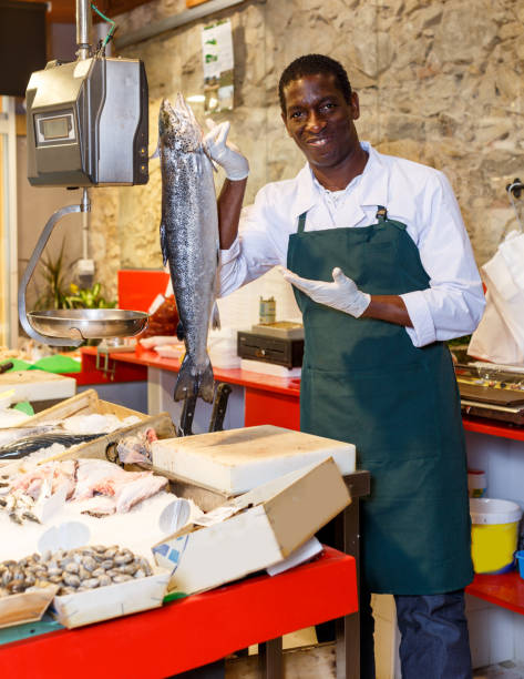 istock Fish shop worker near showcase with raw seafood 1078002418