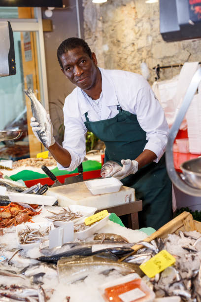 istock Salesman preparing fish for sale 1078002440