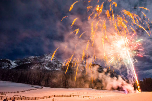 istock Firework for new year's eve in the mountains with some people whatching the explosions 1078008484