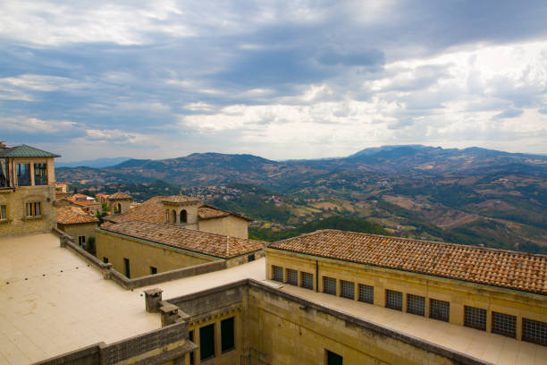 San Marino. Beautiful view to the mountains behind houses with orange roofs. Summertime, Italy. Cloudly sky, heavy clouds.