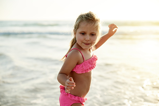 Shot of an adorable little girl enjoying herself on the beach