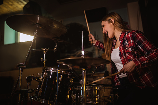 One woman, beautiful brunette playing drums.
