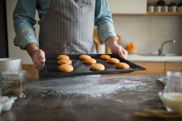 istock Pastry chef holding cooking pan with baked cookies 1078020934