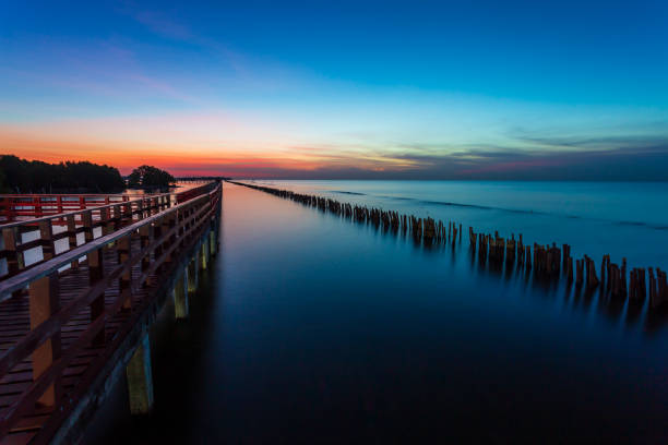 istock Two Wooden pier, jetty and blue lake sunset, sky refle 1078023694