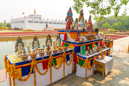 Buddha birthplace in Lumbini and buddhist offerings near sacred pond. Captured in Nepal, spring 2018