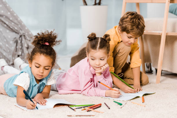 istock beautiful multiethnic kids lying on carpet and studying together 1078027530