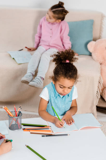 istock adorable african american child studying and writing with pencil 1078027646
