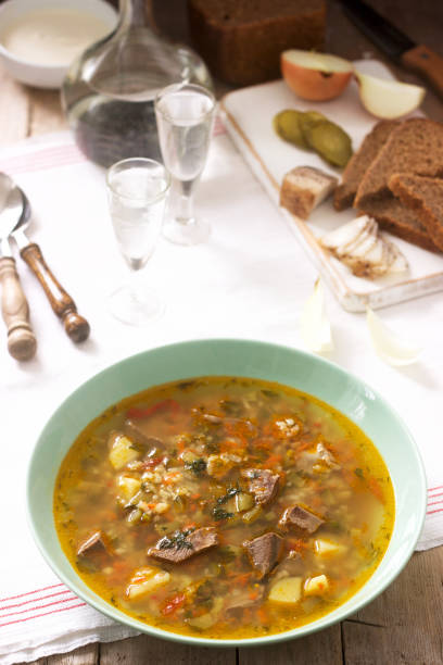 istock Rassolnik, traditional Russian soup, served with various snacks and vodka. Rustic style. 1078033768
