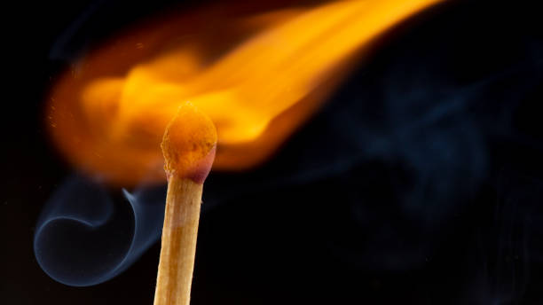 istock Burning wooden match with a red match head on a black background. 1078033846