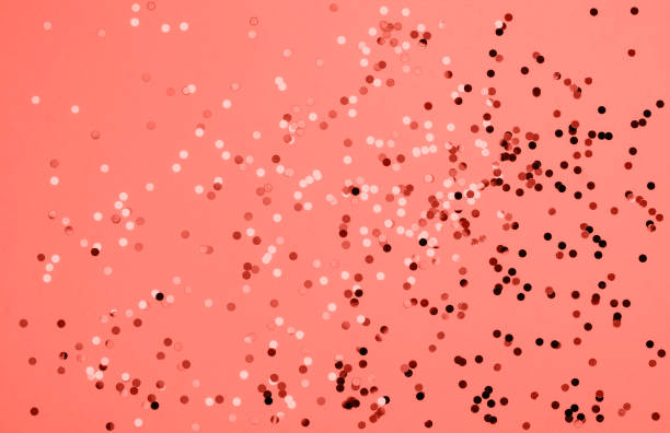 istock Festive pastel coral background with metallic confetti. 1078036194