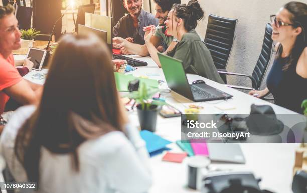 Young Coworkers Team Talking During Startup Happy People Planning A New Project In Creative Workplace Office Focus On Right Top Men Technology Entrepreneur Marketing Concept Stock Photo - Download Image Now