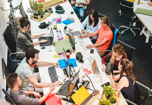 istock Young co-workers team talking during startup - Happy people planning a new project in creative workplace office - Technology, entrepreneur, marketing and concept - Focus on left man with headphones 1078040448