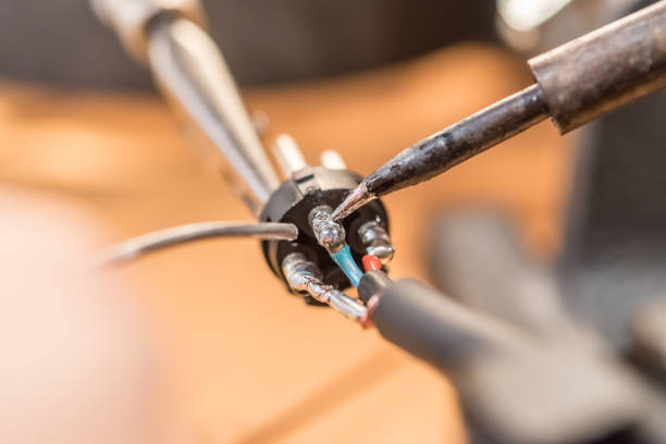 Close Up Man Hands Soldering Audio Cable with XLR Connector Using Soldering Iron