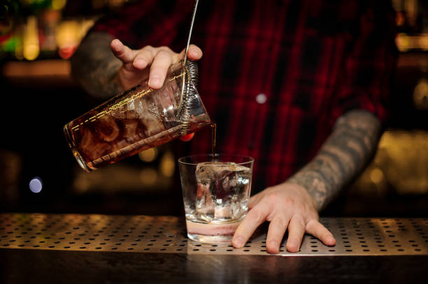 istock Bartender pouring a Godfather cocktail from the measuring cup 1078044016