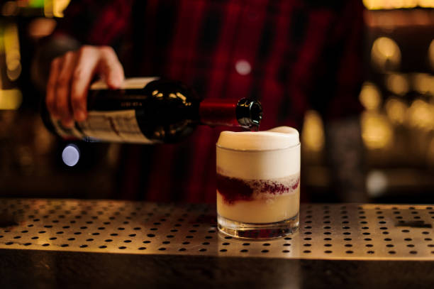 barista versando un vino rosso a un cocktail acido di new york dalla bottiglia - cocktail transparent cocktail shaker glass foto e immagini stock