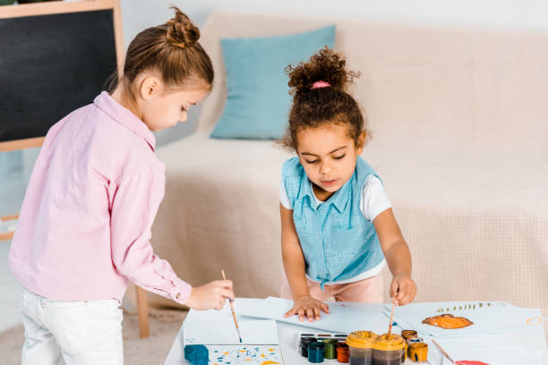 istock beautiful multiethnic kids drawing with paints and brushes together 1078051236