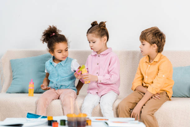 istock adorable multiethnic kids sitting on sofa and playing with soap bubbles 1078051306