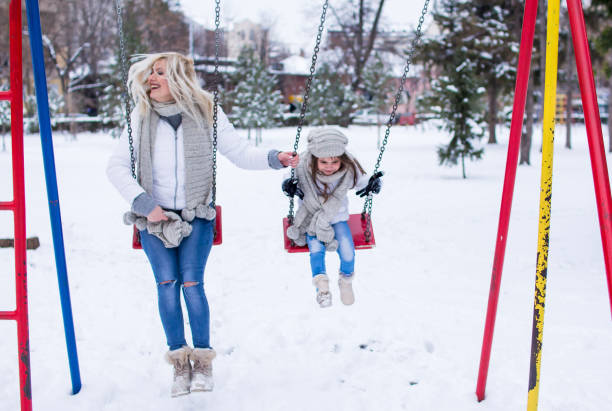 istock Swinging in winter park. 1078053700