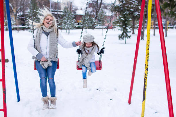 istock Swinging in winter park. 1078053840