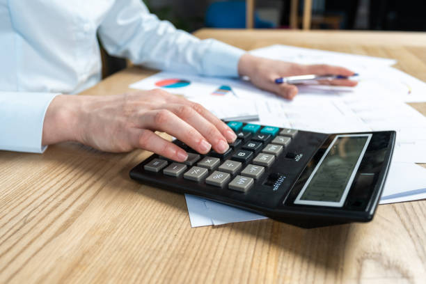 istock Close up cropped sale manager agent or analysis marketer accounting assistant  lady in her formal wear she sit behind table in bright loft interior count investments on calculator focus on hand 1078058896