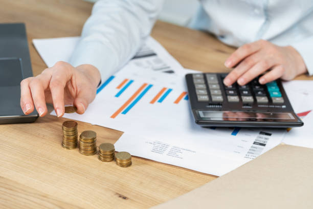Reserves resources revenue concept. Cropped close up broker economist financier sale manager lady in her formalwear she sit behind desktop table in loft interior put capital in stack focus on coins concepto de ingresos de recursos de las reservas. recorta cerca señora de gestor la venta de corredor economista financiero en sus trajes de etiqueta que sentarse detrás de mesa escritorio en loft interior capital puso en foco de la pila de monedas