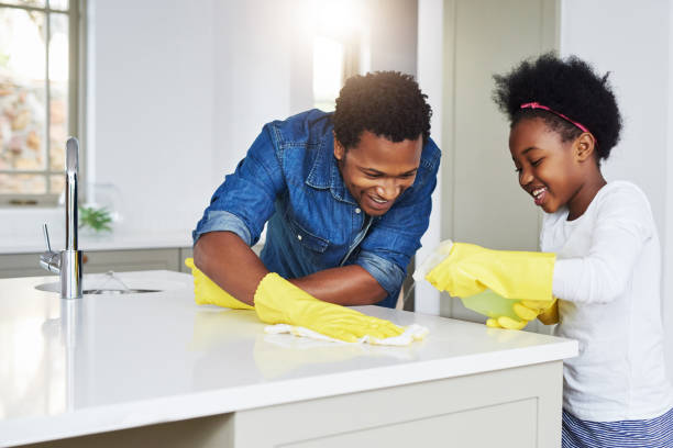 Don't tell mom that dad helps me with my chores Shot of a little girl and her father enjoying their chores at home Dont stock pictures, royalty-free photos & images