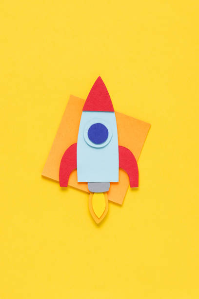 istock top view of flying paper rocket on yellow background, setting goals concept 1078060332