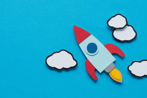 istock top view of cardboard rocket with clouds on blue background, setting goals concept 1078060390