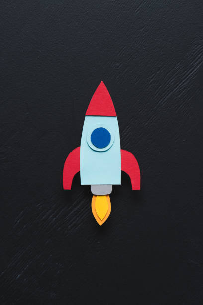 istock top view of flying paper rocket on black background, setting goals concept 1078060436