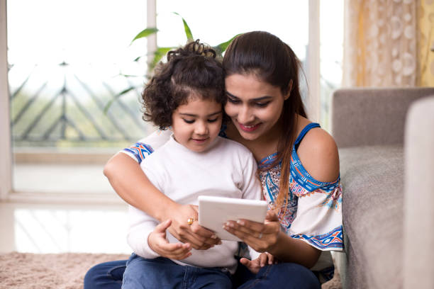 istock Mother with daughter using digital tablet in the living room 1078062310