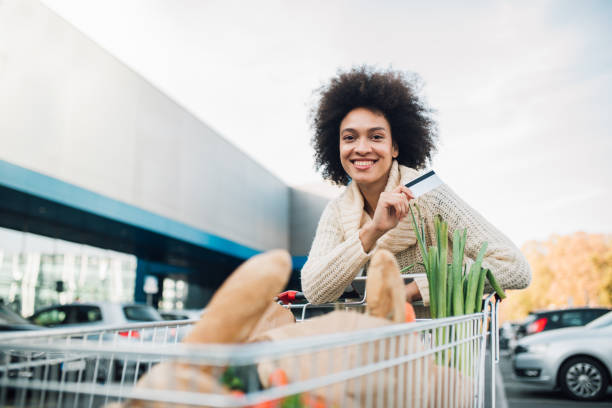 cartão de crédito de exploração de mulher a rir - spending money adult african ethnicity bag - fotografias e filmes do acervo