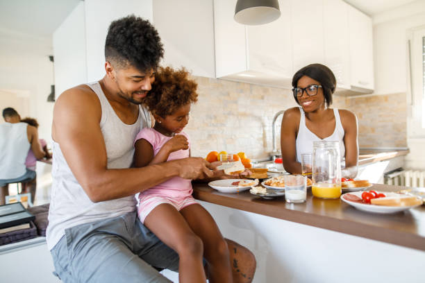 istock Young happy family having breakfast at home 1078076980