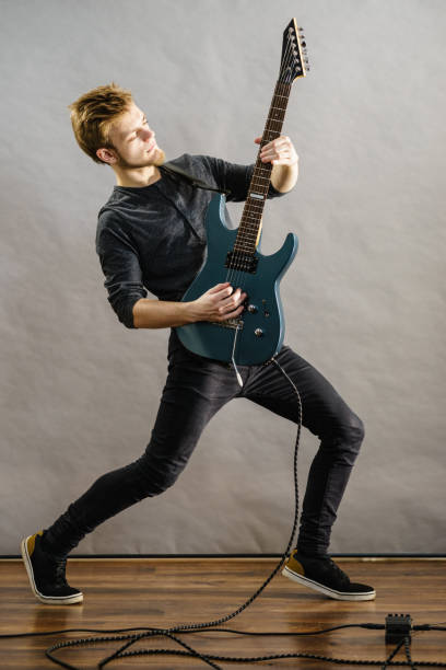 istock Young man playing electric guitar 1078078426