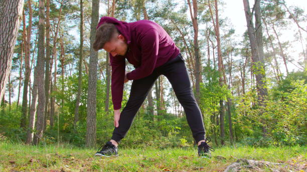 istock Young Man Stretching in the Forest 1078079542