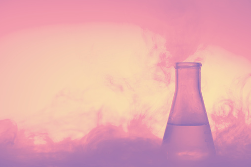 Magic potion in glass tube with liquid and steam in trendy pastel colors with copy space