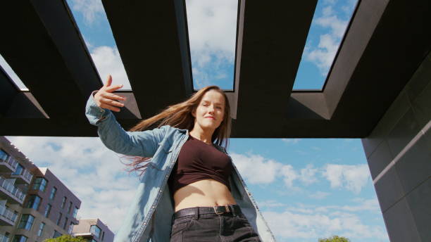 A young woman dancing outside. Medium shot