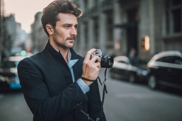 istock Young man photographer holding camera 1078093424