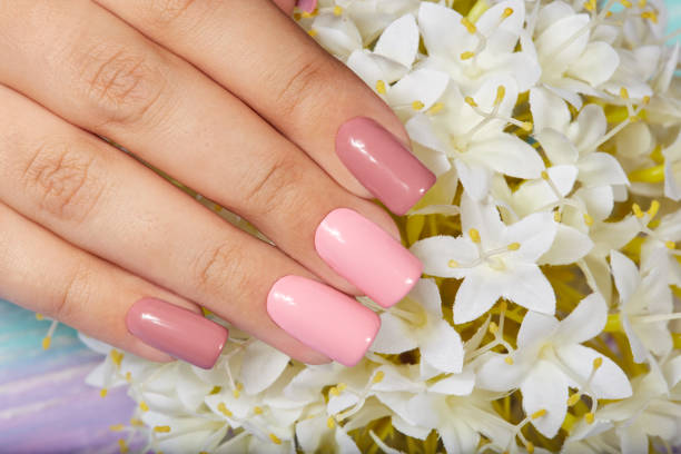 istock Hand with long artificial manicured nails colored with pink nail polish 1078096584