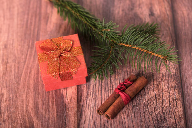 istock Red gift box with pine branch on wooden background 1078097390