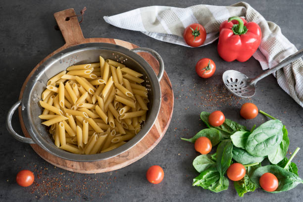 istock pasta in vintage colander, with cherry tomatoes, spinach and bell pepper 1078100488