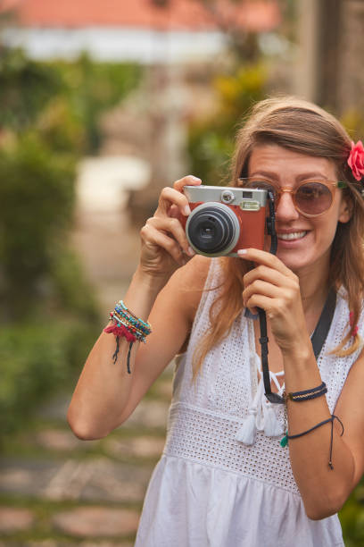 istock Giirl posing with retro vintage camera outdoors. 1078102530