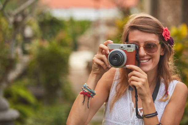 istock Giirl posing with retro vintage camera outdoors. 1078105472