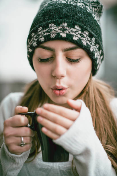 istock Cute Blond Girl With Winter Cap Drinking Hot Cocoa 1078107770
