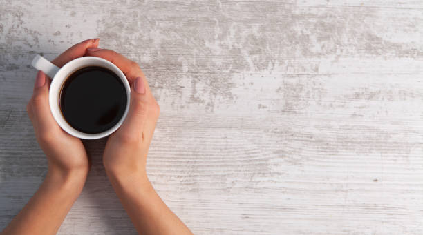 istock hand coffee wooden background 1078109328