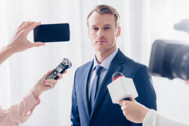istock handsome businessman giving interview to journalists and looking at camera in office 1078115672